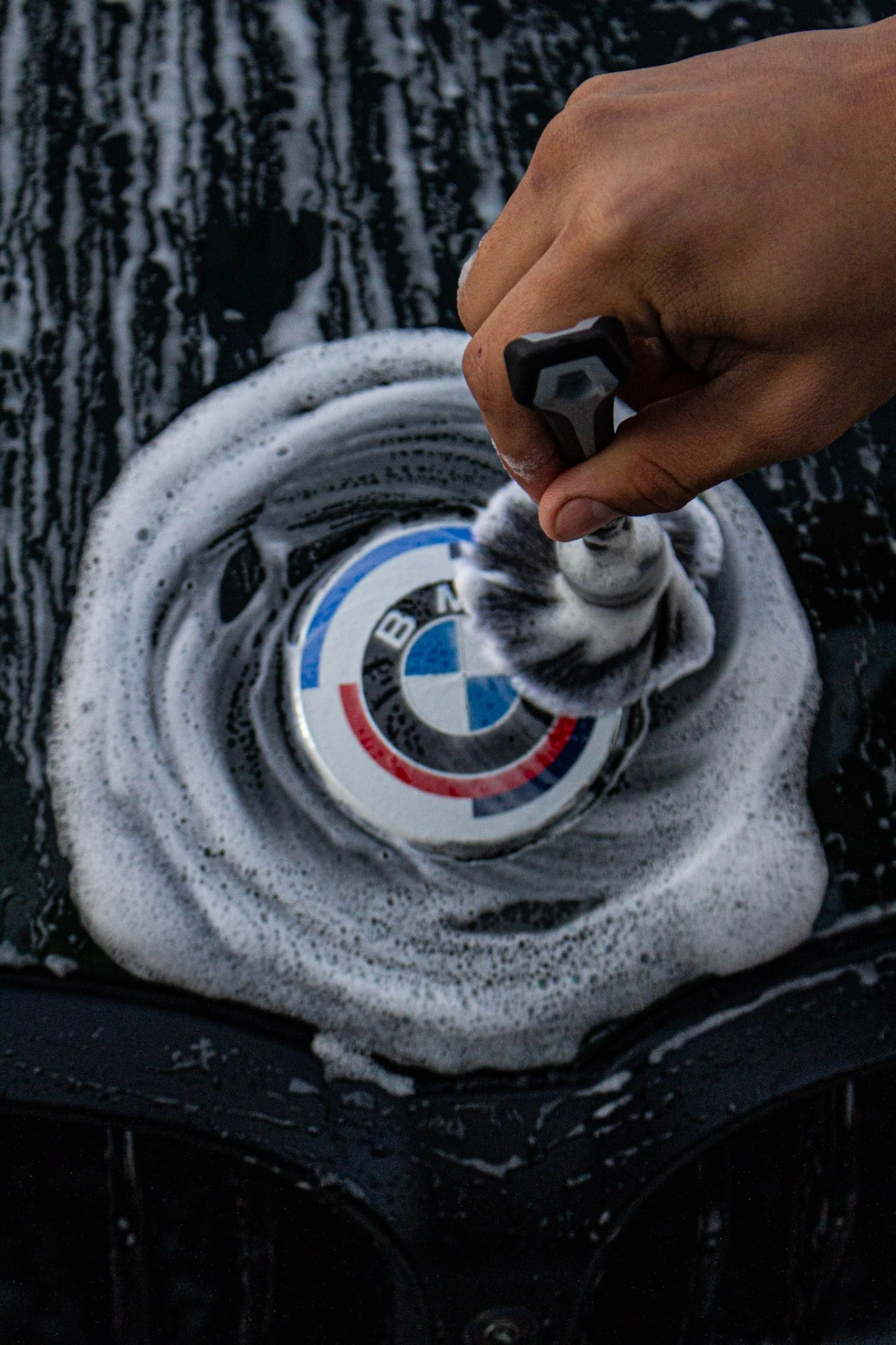 Hand Wash Car Detailing Tri-Cities Washington - Precision Cleaning BMW badge detail brush cleaning Tri-Cities WA - meticulous hand wash and foam application